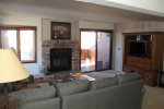 Mammoth Condo Rental Sunrise 16 - Living Room with Woodstove and Access to Outdoor Deck